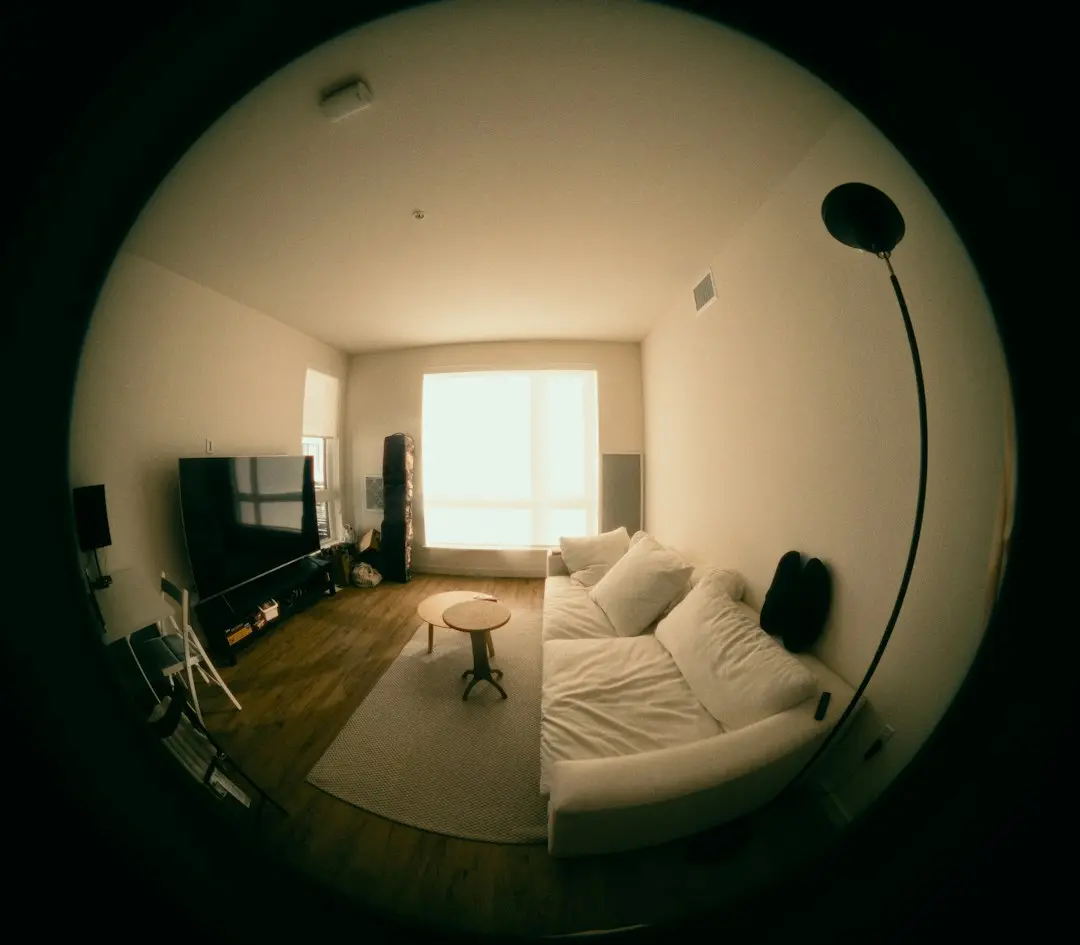 A living room with a flat-screen TV and a white sofa, seen through a fisheye lens: the kind of room where Drogon TV streams over the internet
